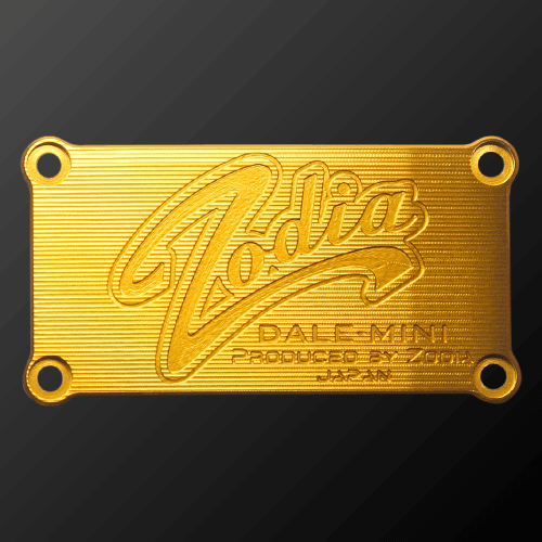 DALE MINI PUTTER CRANK gold plate featuring 'Zodia' and product details in relief design.
