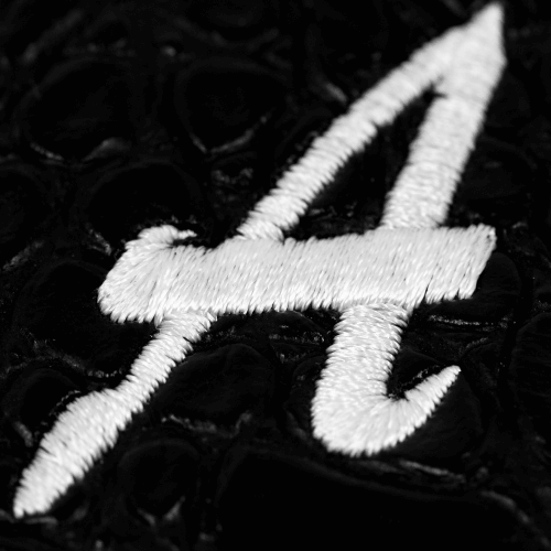 White embroidered number 4 on a black textured surface, highlighting a stylish design.