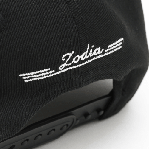 Detail of the Zodia logo on the back of a Metal Badge Cap, showcasing its stylish embroidery and classic design.